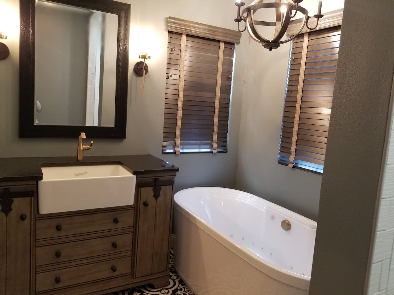 Bathroom remodel with a freestanding tub, farmhouse sink vanity and patterned tile floor