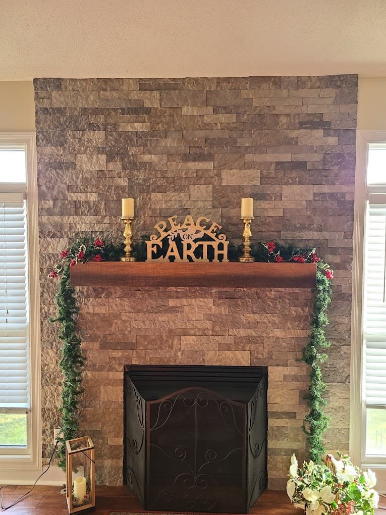 Floor-to-ceiling stacked stone fireplace with a timber mantel