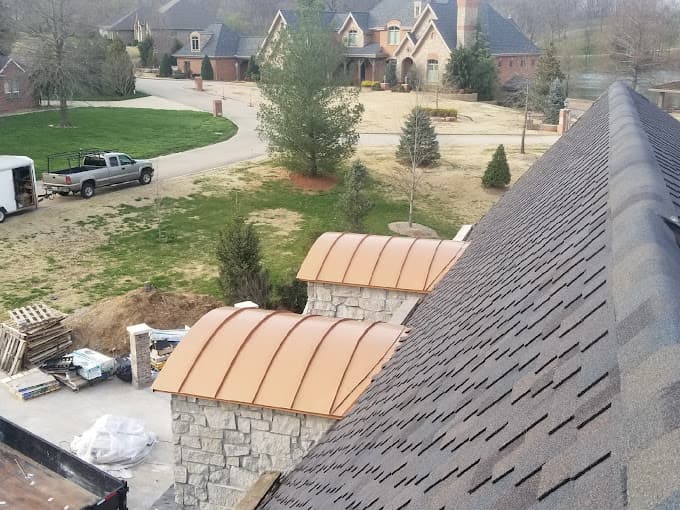 Copper standing-seam roofs over two stone bay windows