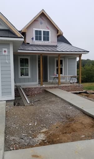 New concrete walkway leading to the covered front porch of a new home