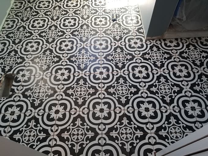 Black and white patterned tile floor laid during a bathroom remodel